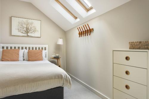 a bedroom with a white bed and a dresser at Exceptional 3 Bedroom River View Apartment - Pass the Keys in Ulverston