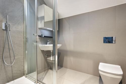 a bathroom with a shower and a toilet and a sink at Exceptional 3 Bedroom River View Apartment - Pass the Keys in Ulverston