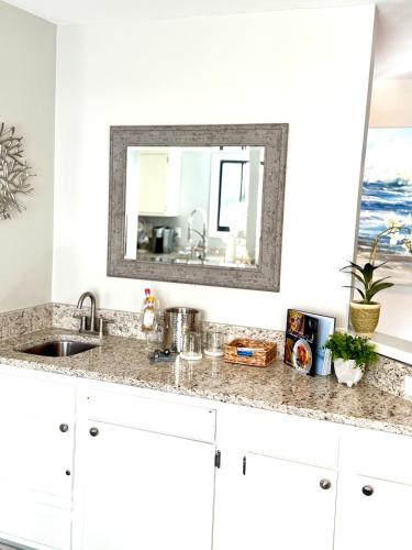 a kitchen counter with a sink and a mirror at Boutique Coastal Retreat in Edisto Island