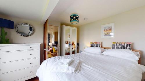 a bedroom with a white bed and a dresser at E08 Boness E8, Riviere Towans in Hayle