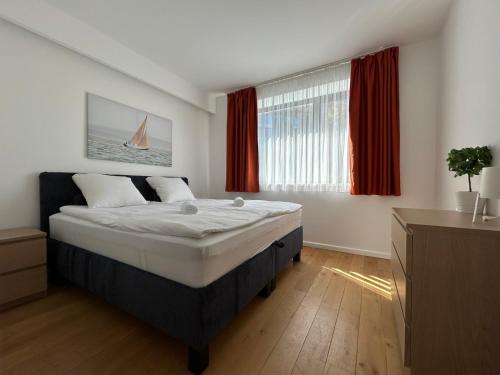 a bedroom with a large bed and a window at Prime Apartmans in Balatonlelle