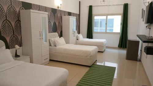 a living room with two beds and a couch at AlWasl Guesthouse by PHM in Dubai