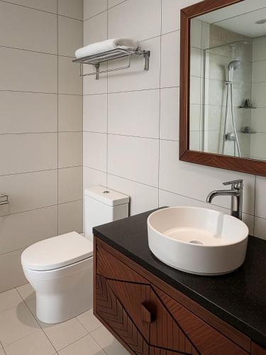 a bathroom with a sink and a toilet and a mirror at Blue View Apec Tuy Hoa in Tuy Hoa