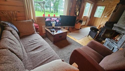 a living room with a couch and a table at Authentic Finnish Lakeside Cottage in Lusila