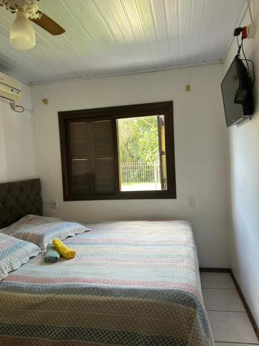 a bedroom with a bed with a banana on it at Pousada Familiar da Dani - Casa em São Gabriel com piscina in São Gabriel