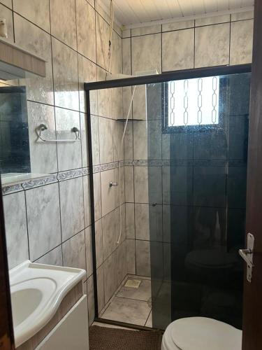 a bathroom with a shower and a toilet and a sink at Pousada Familiar da Dani - Casa em São Gabriel com piscina in São Gabriel
