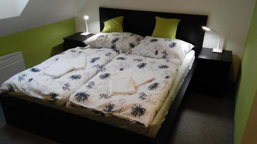 Bett mit blauer und weißer Bettwäsche und Kissen in der Unterkunft Bed & Parking Eurobit in Hrušky