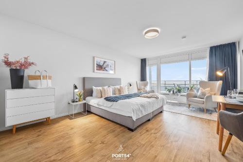 a white bedroom with a bed and a desk and a desk at Ferienwohnung Seeblick 203 Büsum in Büsum