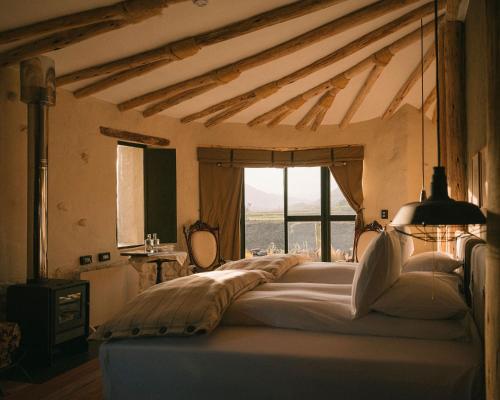 a bedroom with a large bed with a large window at PUQIO by Andean in Yanque