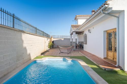 a swimming pool in the backyard of a house at Sueños De La Vega in Las Gabias