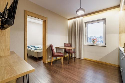 a room with a table and a bed and a window at Apartamenty Polna 60 in Żory