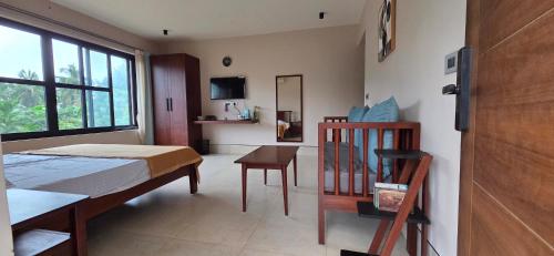 a bedroom with a bed and a table and a window at Nirmala's Farmhouse - The Blu room in Kuttālam