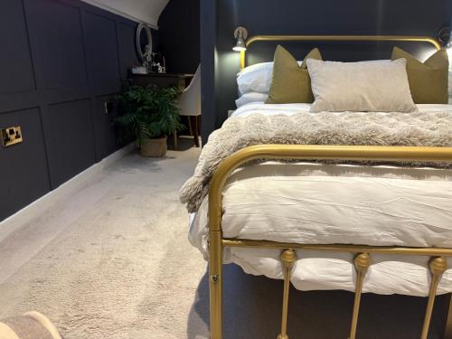 a bedroom with a bed with a gold frame at The Old Farmhouse in Bristol