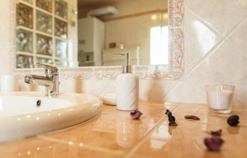 ein Badezimmer mit einem Waschbecken, einem Spiegel und Blumen in der Unterkunft Terrazza San Pietro in Rom