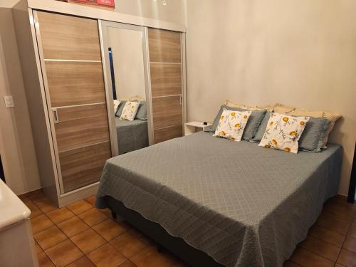 a bedroom with a bed with pillows and a mirror at Casa a 4 km do centro e Shopping Campo Grande in Campo Grande