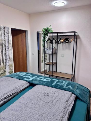 a room with a bed in a room with a shelf at MeLou FeWo NaturQuartier Wellness in Bad Lauterberg