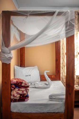 a bed with a canopy bed with a swan on it at Sisama Lodge in Msaranga