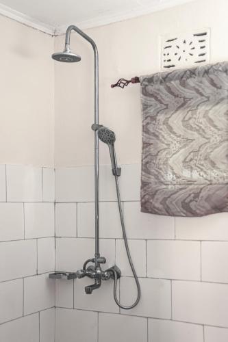 a shower with a hose in a bathroom at Sisama Lodge in Msaranga