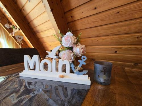 a table with a sign that says mum with pink roses at Haus Stern Carolinensiel in Carolinensiel