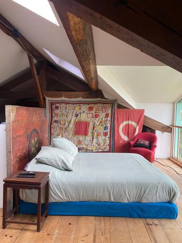 a bedroom with a king sized bed and a table at Maison au coeur de Guéthary in Guéthary