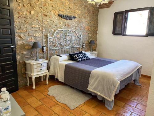 a bedroom with two beds and a stone wall at La iaia Merce in L'Aldea