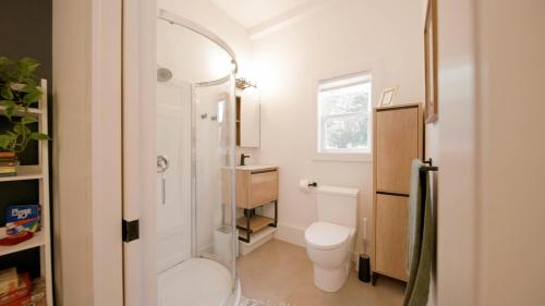 a small bathroom with a toilet and a shower at Flora Studio on the Lake in Saint Martins