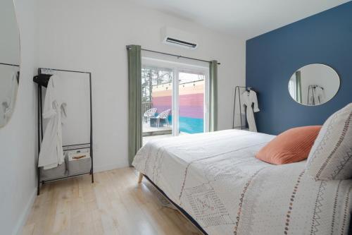 a bedroom with a bed with a blue wall and a mirror at Flora Studio on the Lake in Saint Martins