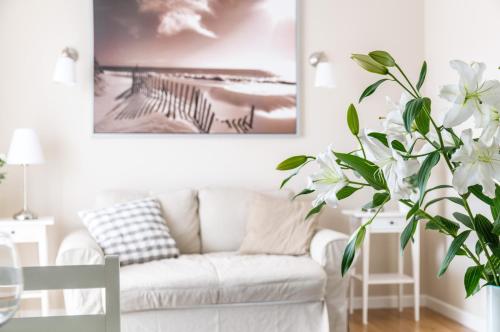 a living room with a white couch and a plant at EUROPA22 "TU i TERAZ" Apartament Przytulny CENTRUM MIASTA Tomaszów Maz PARKING gratis EXPRESOWE zameldowanie od 13 in Tomaszów Mazowiecki