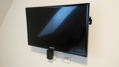 a flat screen tv hanging on a wall at Bed & Parking Eurobit in Hrušky