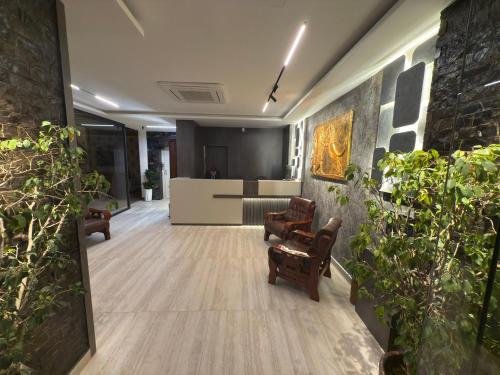 a hallway with chairs and plants in a building at Al-Rabie Hotel & Apartments in Baghdād