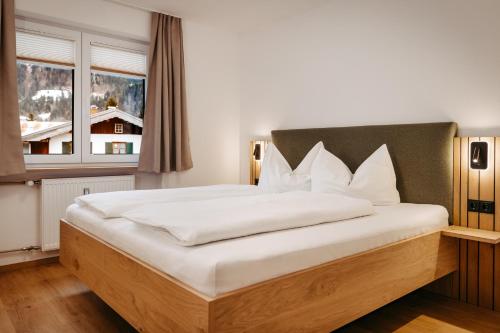 a bedroom with a large white bed with a window at Schöne Aussicht in Riezlern