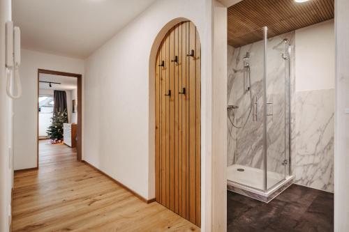 a bathroom with a shower and a wooden door at Schöne Aussicht in Riezlern