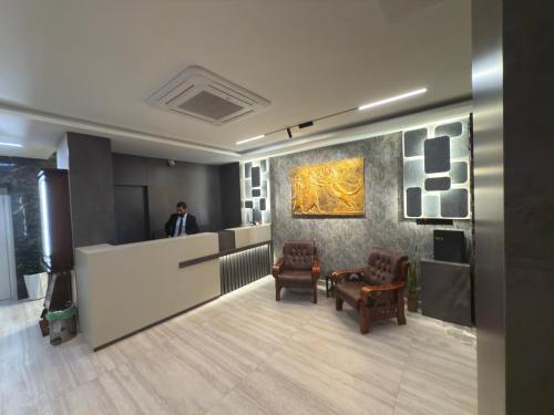 a man standing at a counter in a lobby at Al-Rabie Hotel & Apartments in Baghdād