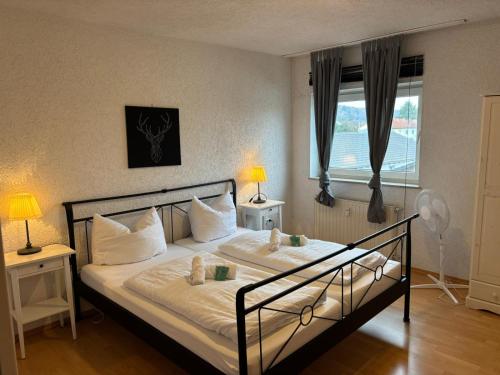 a bedroom with a bed with white sheets and a window at Apartmenthaus - Mackenbach in Mackenbach