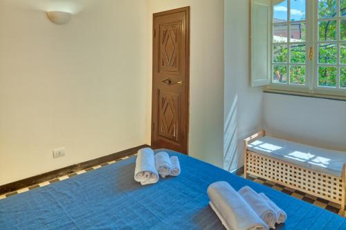 a bedroom with a blue bed with towels on it at PORTOVECCHIO Extra in Levanto