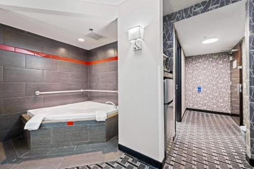 a bathroom with a tub and a shower at Comfort Suites Williamsburg Historic Area in Williamsburg