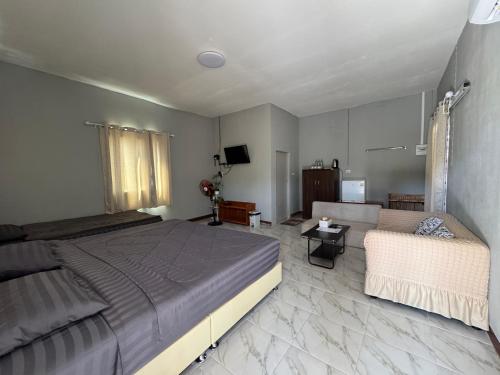 a bedroom with a large bed and a couch at Phak Ploen Home Stay in Ban Rae Mai Phai