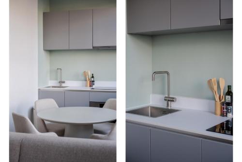 a kitchen with white cabinets and a white table at Modern One Bedroom Apartment - Rotterdam West in Rotterdam
