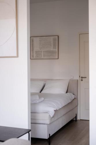 a bed in a white room with a picture on the wall at Modern One Bedroom Apartment - Rotterdam West in Rotterdam