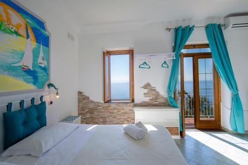 a bedroom with a large white bed and a window at Villa Gioiello in Amalfi
