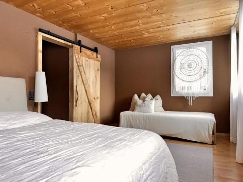 a bedroom with two beds and a wooden ceiling at Revier beau jardin in Glarus