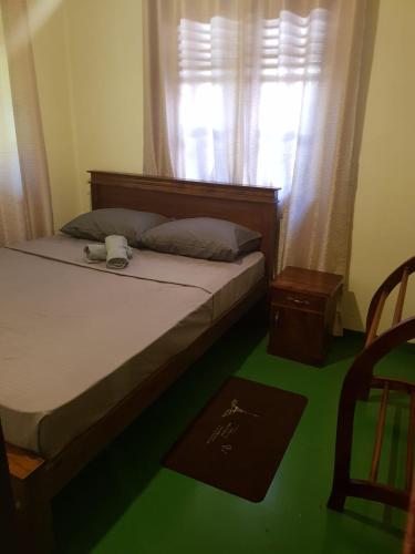 a bedroom with a bed with a window and a green floor at Villa Golden Drift in Ahangama