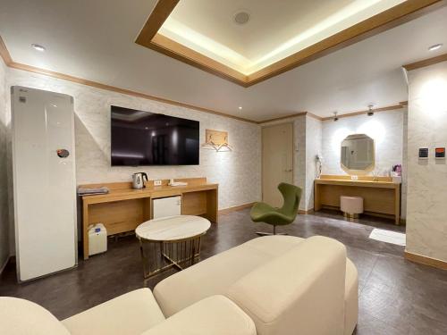 a living room with a couch and a table and a desk at Gallery Motel in Seongnam