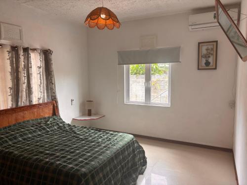 a bedroom with a bed and a window at La maison des vacances in Cap Malheureux