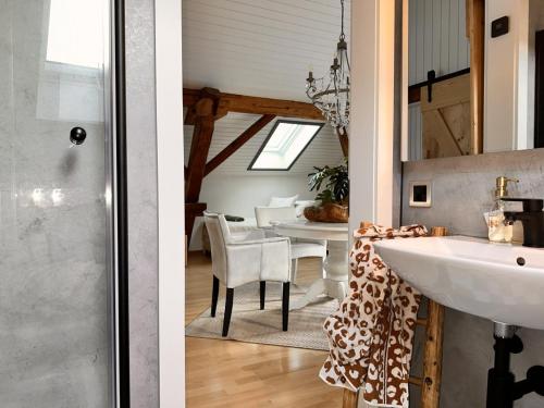 two images of a bathroom with a sink and a dining room at Revier belle étage in Glarus
