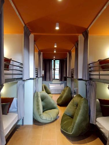 a room with three bunk beds with bean bags at Nitra Hostel Siriraj in Bangkok