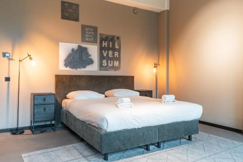 a bedroom with a large bed with white sheets at Hilversum City Apartments in Hilversum