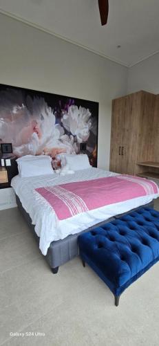 a bedroom with a large bed with a large painting on the wall at Fynbos N Sea in Gansbaai