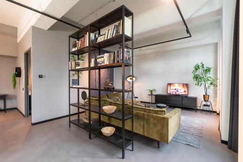 a living room with a large book shelf at Hilversum City Apartments in Hilversum