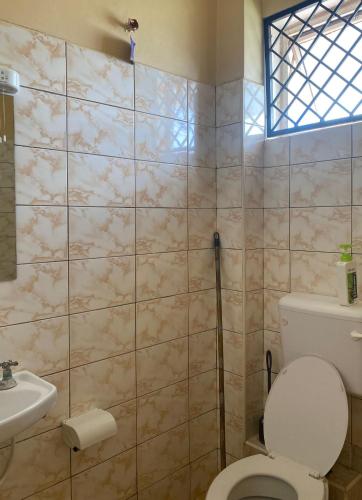 a bathroom with a toilet and a sink at SuNRISE LUXURY HOMES in Mtwapa